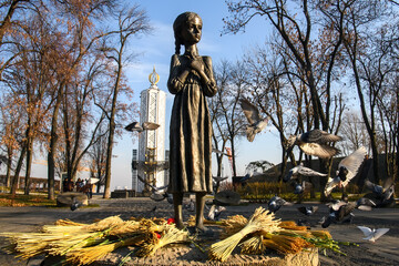 Pigeons fly near Monument to the victims of Holodomor big hunger in Ukraine who died of starvation...