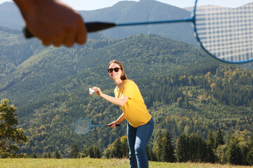 Woman playing badminton in mountains on sunny day