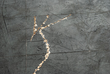 Putty dark gray background under the tiles in the style of kintsugi