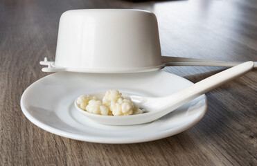 Kefir grains on a white spoon and a white sieve