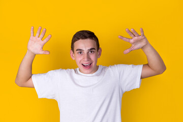 A handsome guy in a white t-shirt  gesticulating on a yellow background