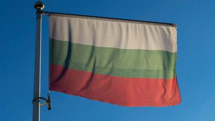 National flag of Bulgaria on a flagpole in front of blue sky with sun rays and lens flare. Diplomacy concept.