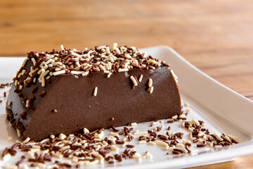 Chocolate pudding with sprinkles, delicious chocolate dessert on wooden table