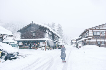 雪が降る中で傘をさす女性