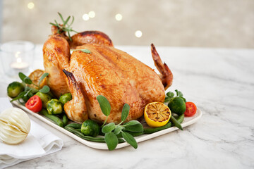 Festive celebration chicken with herbs for Thanksgiving or Christmas on wooden background.