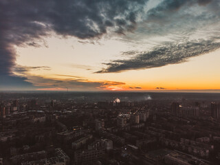 Aerial sunset evening view on residential Kharkiv city Pavlove Pole district. Multistory buildings district with scenic bright orange cloudy sky on horizon
