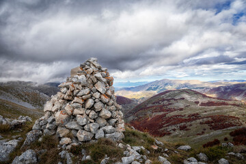 Autumn landscape on the top of the mountain, rocky surface and beech forest in the distance.
