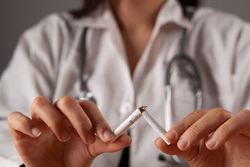 hands doctor break a cigarette close-up. smoking harm concept.