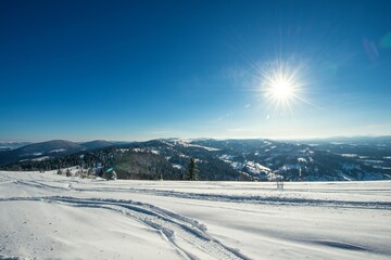 ATV and ski tracks in snow on frosty winter day