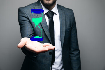 a man holds a virtual hourglass in his hand