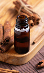 concept of natural cosmetics, glass bottle with oil, cinnamon sticks