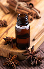 concept of natural cosmetics, glass bottle with oil, anise seeds and cinnamon sticks