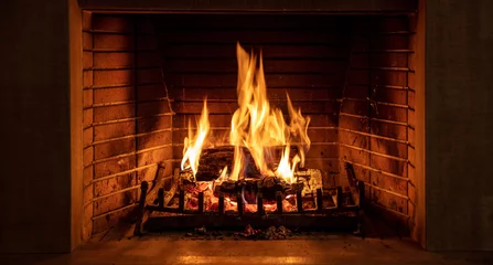 Foto op Plexiglas Kersttijd, gezellige open haard. Houtblokken branden, vuurstenen achtergrond, ontspanning en warm huis © Rawf8