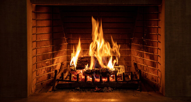 Christmas time, cozy fireplace. Wood logs burning, fire bricks background, relaxation and warm home