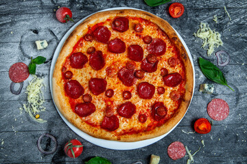 Pizza with salami and sausages on wood background.