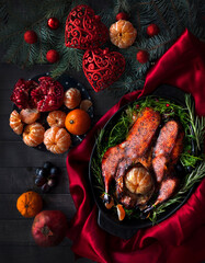 Roast Christmas duck with oranges and tangerines on a rustic wooden table decorated with fir branches - 469970734