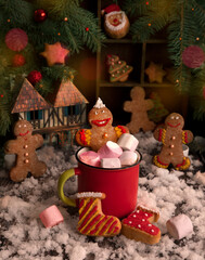 Gingerbread men bathe in a red cup with marshmallows, Christmas has come, gingerbread houses in the background. Christmas concert. - 469970737