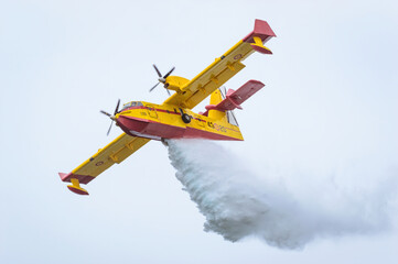 Fototapeta na wymiar Firefighting seaplane collecting water in the sea.