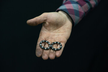 Repair and restoration of old bicycles. The mechanic holds an old bottom bracket and bearings in...