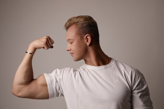 Muscular young man showing off his defined biceps. Life style and bodybuilding.