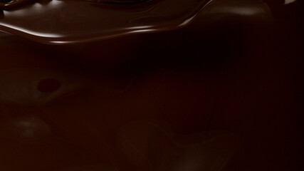 Closeup of splashing dark melted chocolate