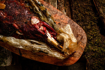 smoked meat. beef leg cooked in a smokehouse on woody background