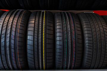 Close up new tyres on shelve in tire shop. Car tires on rack in auto store.