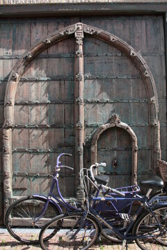 Zwei Fahrräder stehen in Holland vor einem Tor parkend