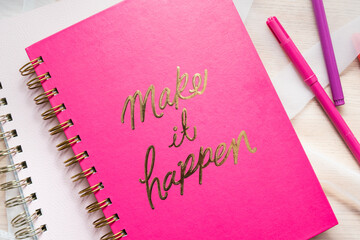 Notebook with a make it happen sign, purple notepad