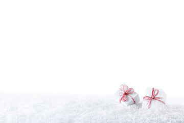 Two gift boxes tied with red and white ropes on snow. Isolated on white background. Merry Christmas and Happy New Year greeting card with copy space.