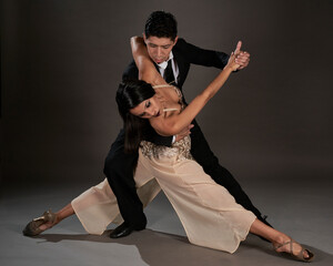 couple of latin woman and asian man dancing tango in studio - obrazy, fototapety, plakaty