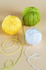 Multicolored woolen thread  on beige background. Handiwork, leisure, hobby concept.Copy space..