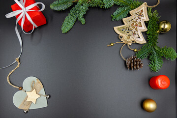 New Year's background. Christmas decorations and fir branches on a black background. Top view.