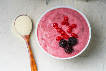 Vegan dessert. Semolina mousse with berries in a white bowl. Top view, close-up.