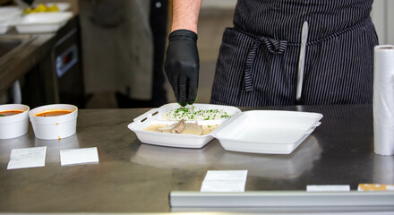 Chef preparing takeaway dish in the restaurant or pub , food delivery concept, home delivery, online order