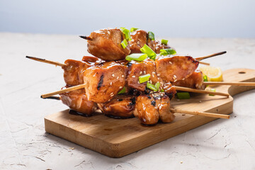 Chicken fillet yakitori close-up. Delicious chicken pieces on skewers cooked on the grill. Asian...
