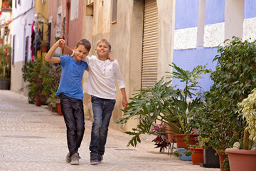 Fototapeta na wymiar Two happy kids outdoors in the street european city on summer day