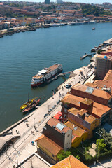 Fototapeta na wymiar top view of a cruise liner and a vintage boats for transporting port wine on the Douro river in the Portuguese city of Porto