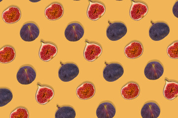 Creative pattern of fresh ripe whole and sliced figs on yellow background.