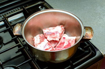 Preparing meat broth for soup. Meat in a saucepan on the stove.