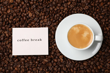 Cup of aromatic hot drink and card on beans, flat lay. Coffee break