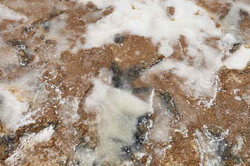 Abstract nature background seashore. Texture of sea salt on the beach. The remains of sea salt frozen in time in the land. Salt lake in the desert. Mining of minerals. Top view