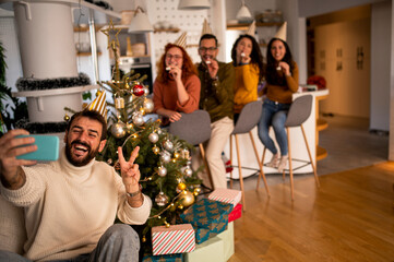 Happy friends in the house for the new year holidays. Christmas party x-mas holidays making selfie in house full of noel decoration.