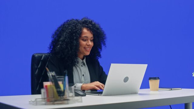 Green Screen Office Background: Black Businesswoman Sitting at Her Desk Working on a Laptop Computer. African American Woman working with Big Data e-Commerce. 360 Degree Tracking Shot. Moving Around