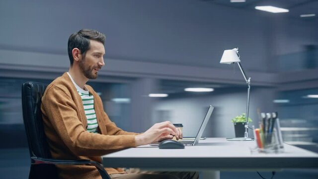 360 Degree Modern Office: Handsome Businessman Sitting at His Desk Working on a Laptop Computer. Man working with Big Data e-Commerce Analysis. Energetic Fast Tracking Shot. Camera Moving Around