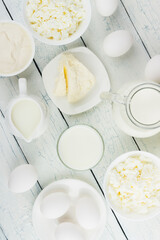 Different dairy products on the white wooden boards