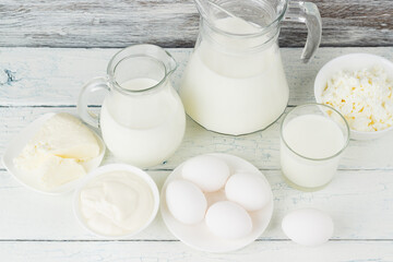 Different dairy products on the white wooden boards