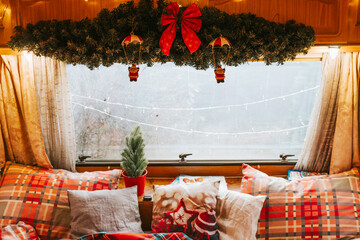 cozy bedroom interior in trailer of mobile home or recreational vehicle, concept of family local travel in native country on caravan or camper van and camping life in winter, Christmas and New Year