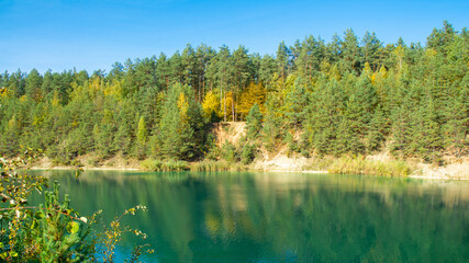 Fototapeta na wymiar panorama view of fall colors reflecting on the surface of a lake - park, Luban, Belarus