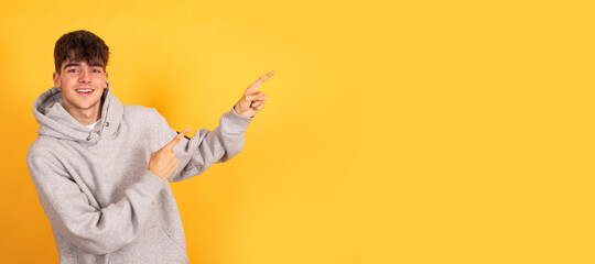 isolated teen boy pointing on background with space